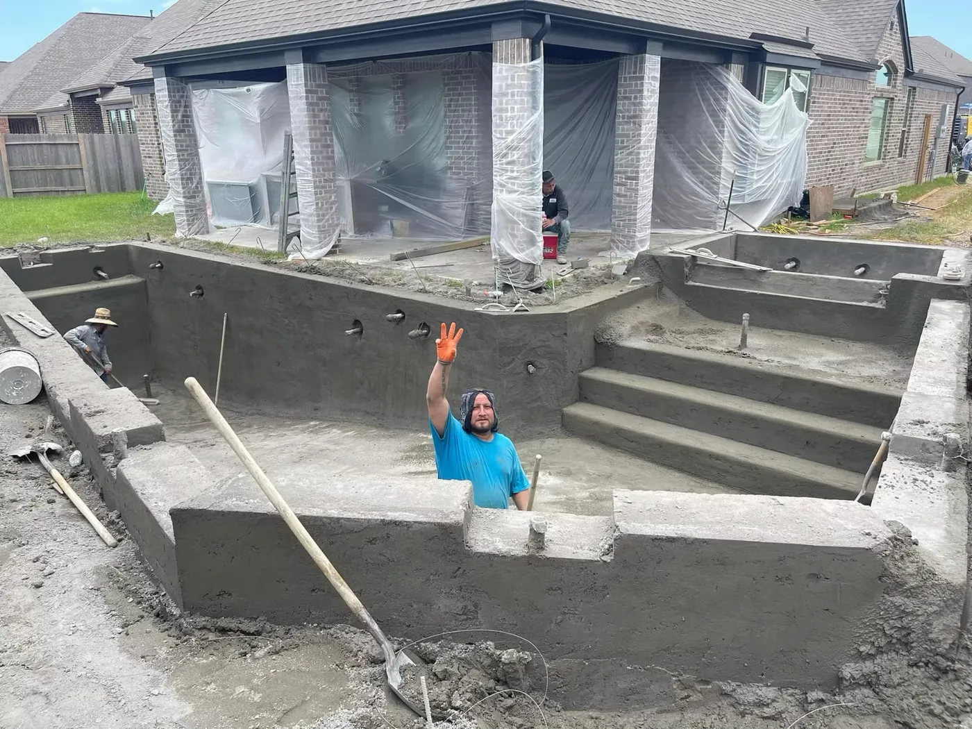 Worker inside gunite pool shell during construction