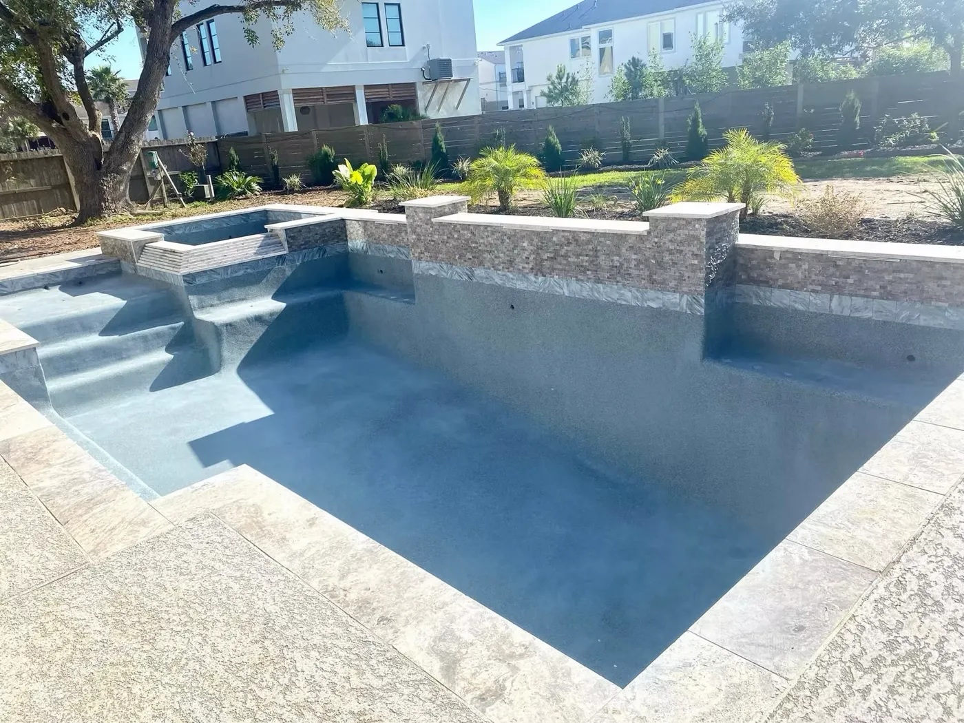 Elegant rectangular pool with steps and water wall feature built by Aquatic Pools