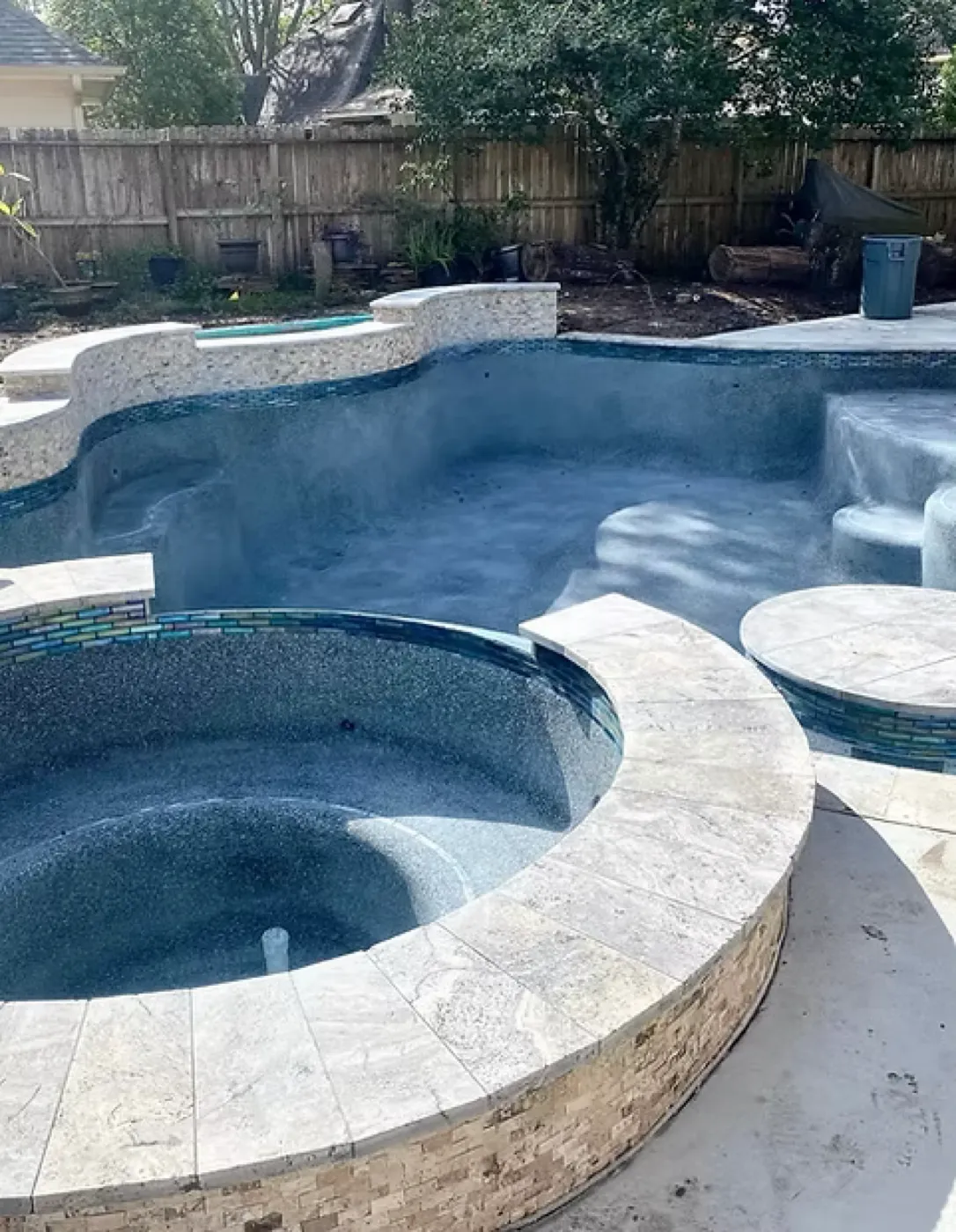 Freeform pool with round tiled spa