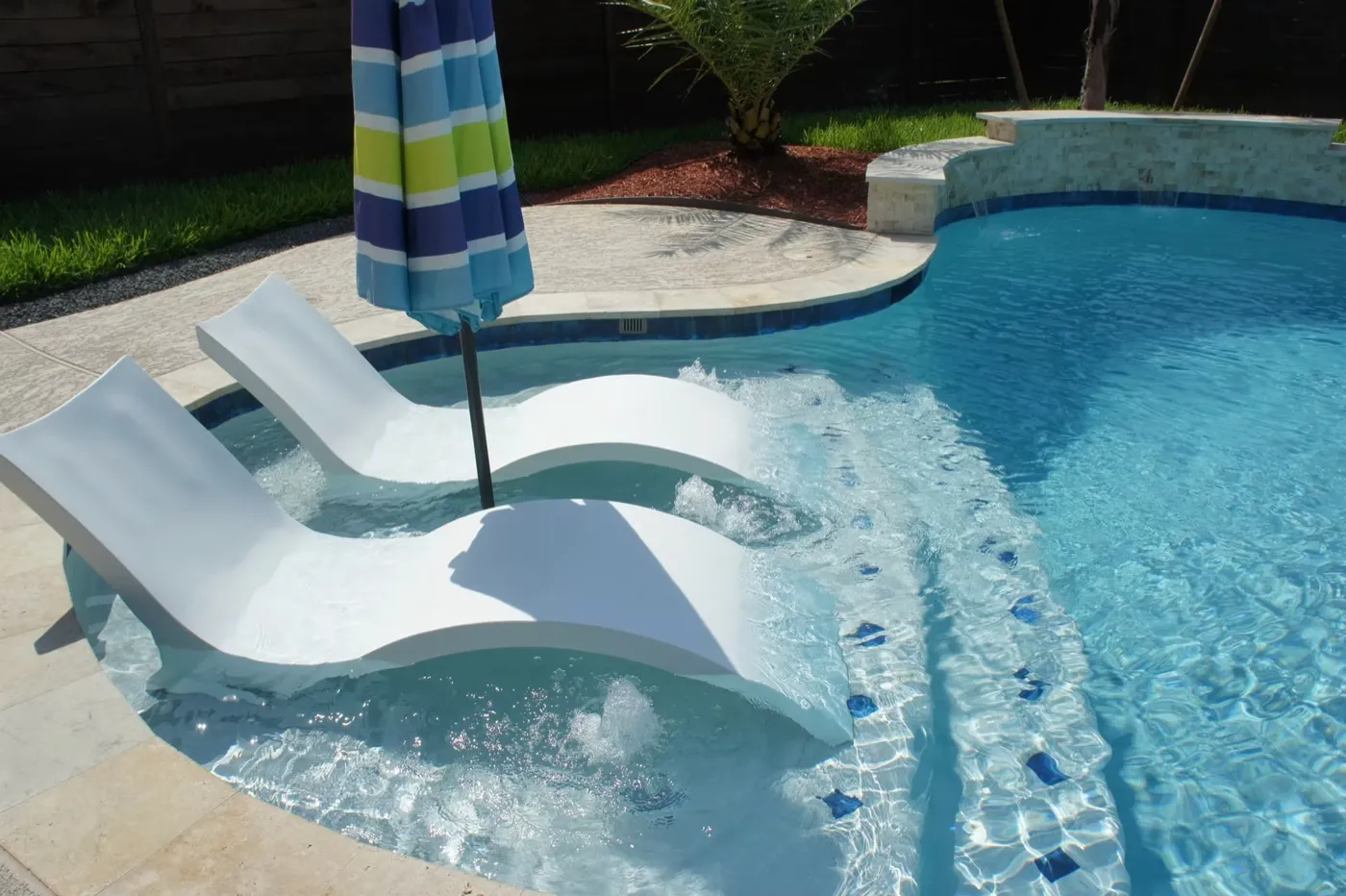 Pool with in-pool tanning ledge and loungers