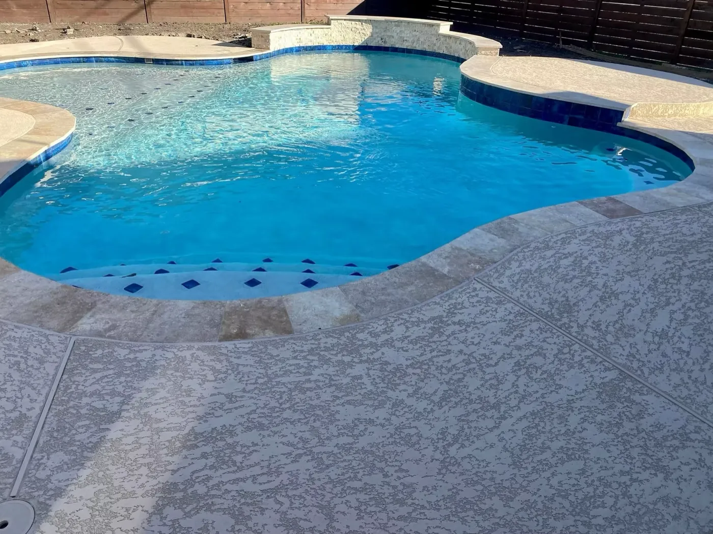 Pool with raised wall waterfall feature