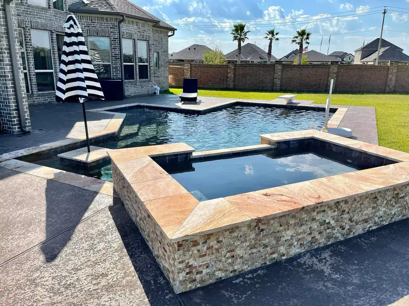 Pool with elevated stone spa