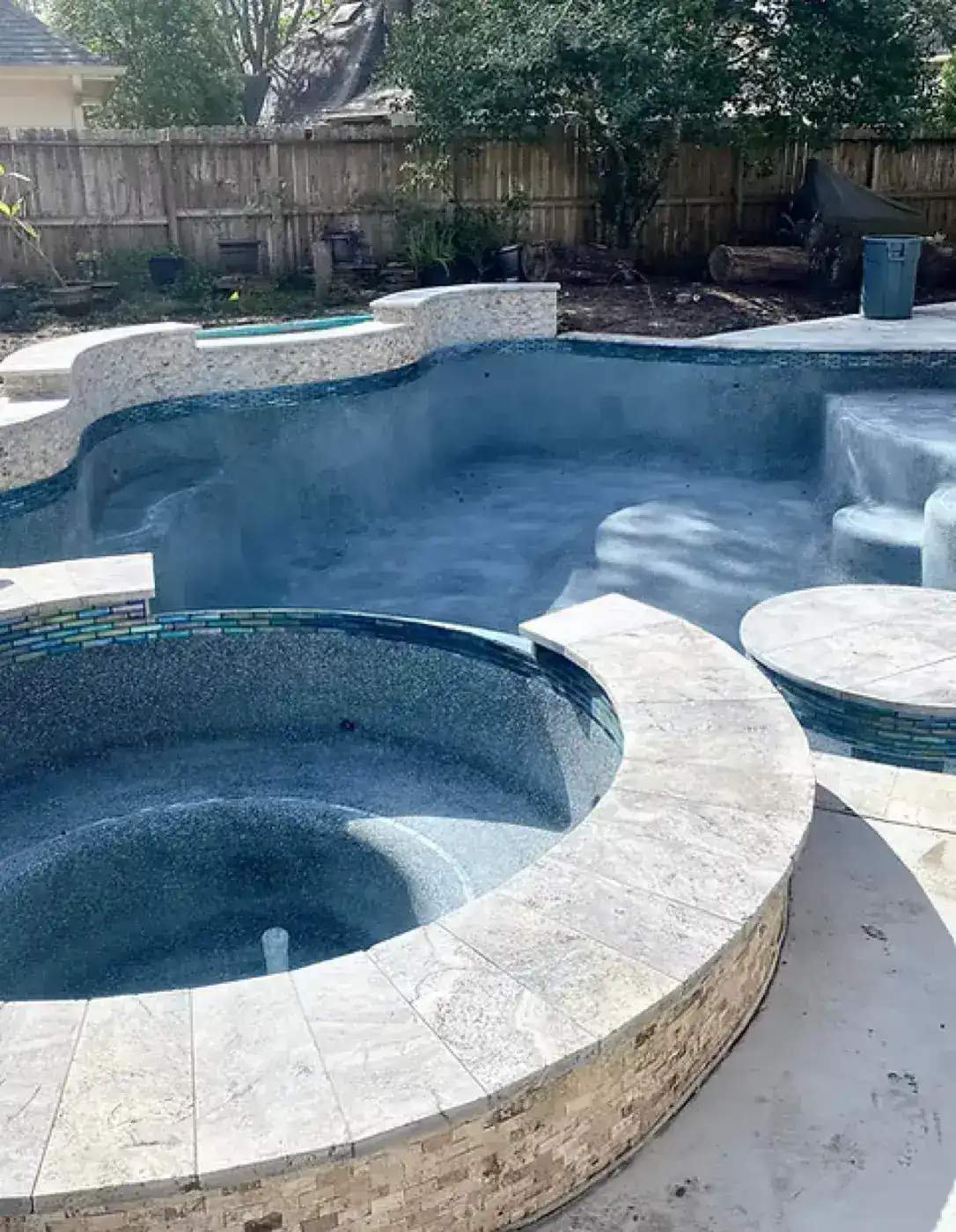 Freeform pool with round tiled spa